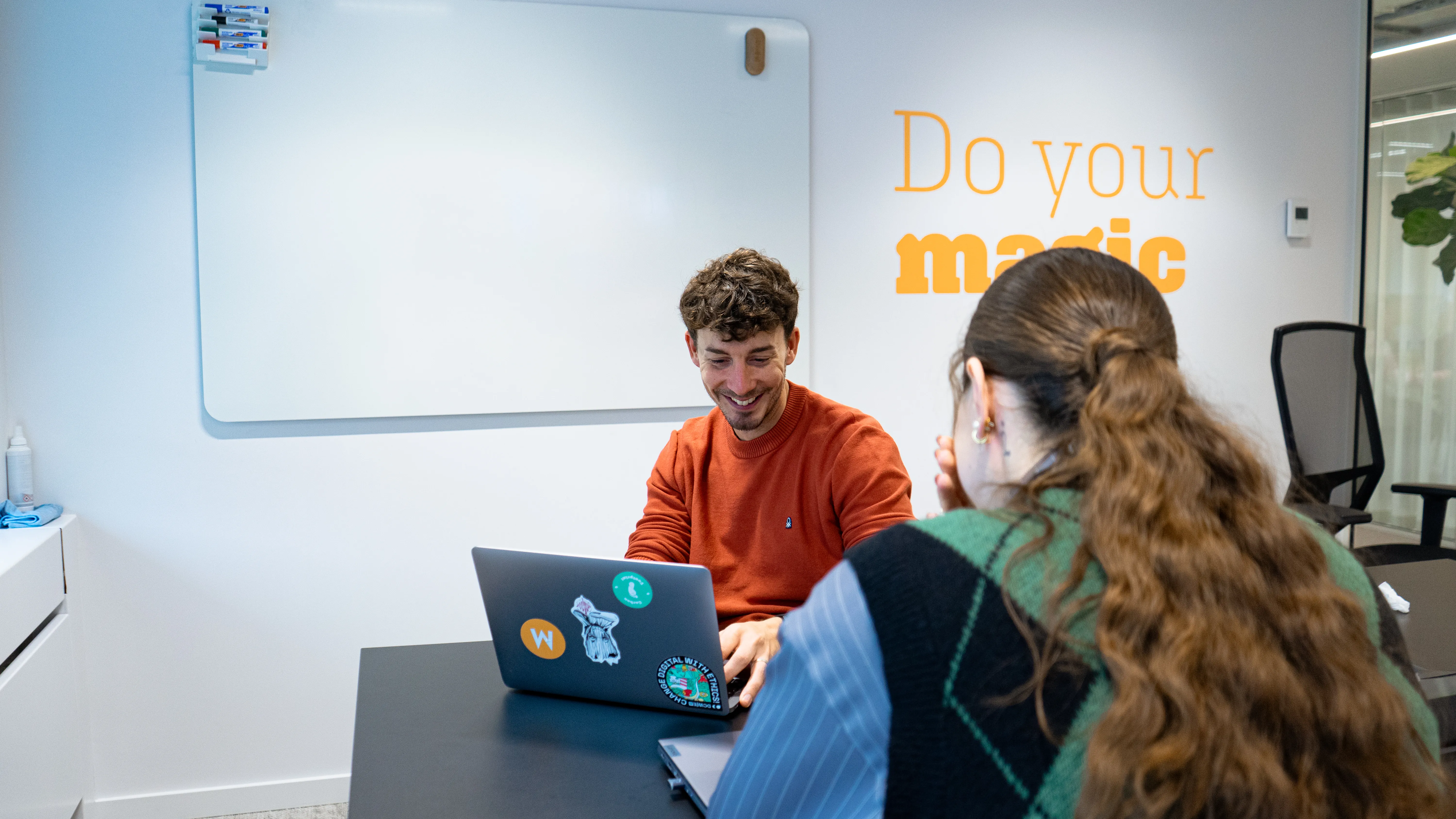 Deux collègues travaillant sur un ordinateur portable dans un bureau moderne