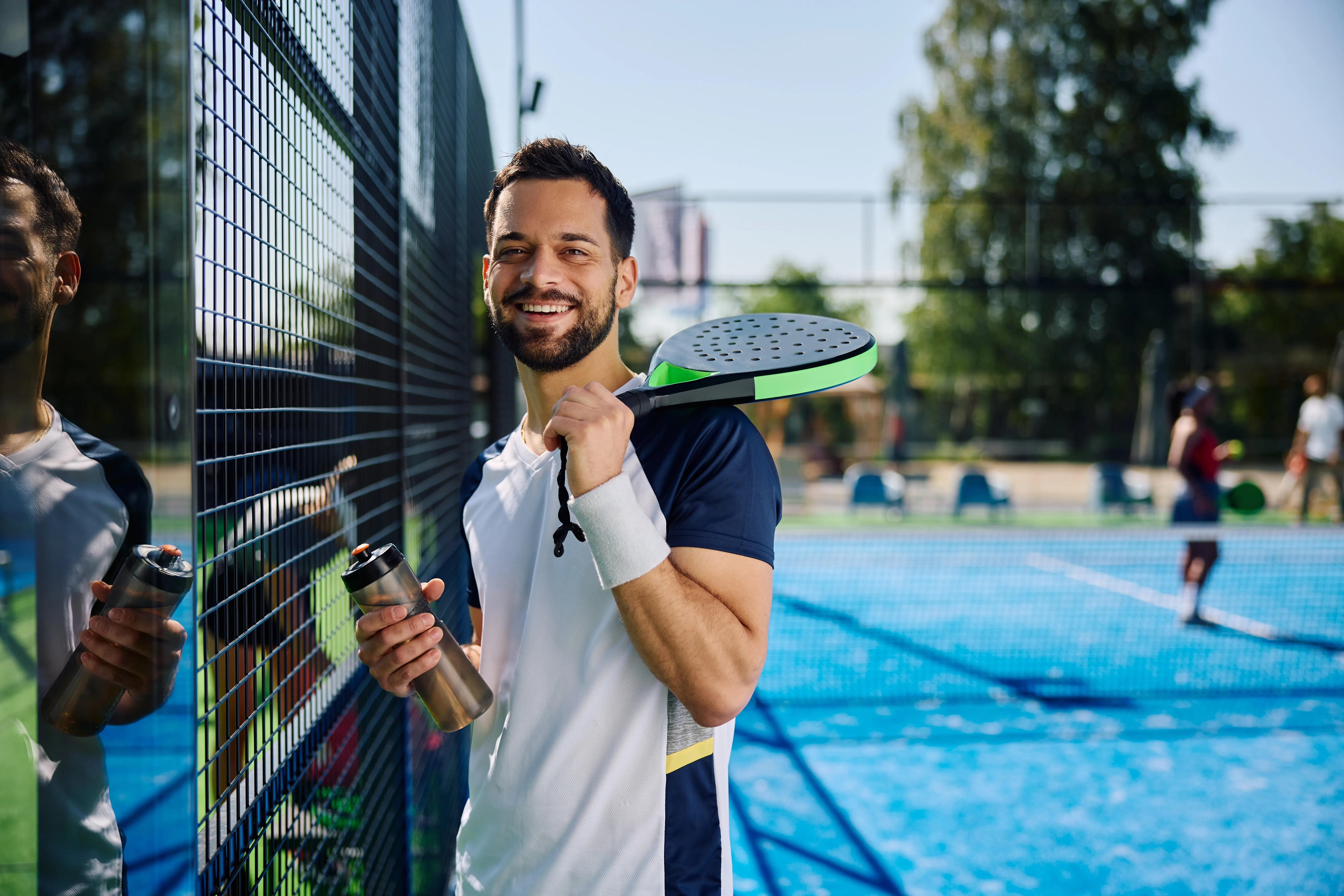 Homme avec raquette de padel sur un terrain extérieur